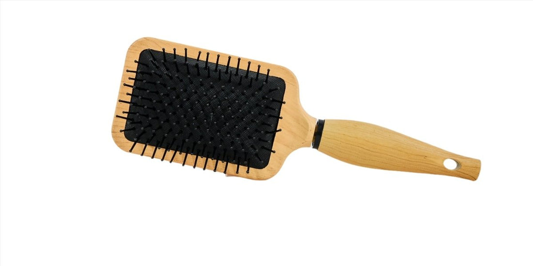 Large wooden hair brush with black bristles on rectangular paddle and thumb hole